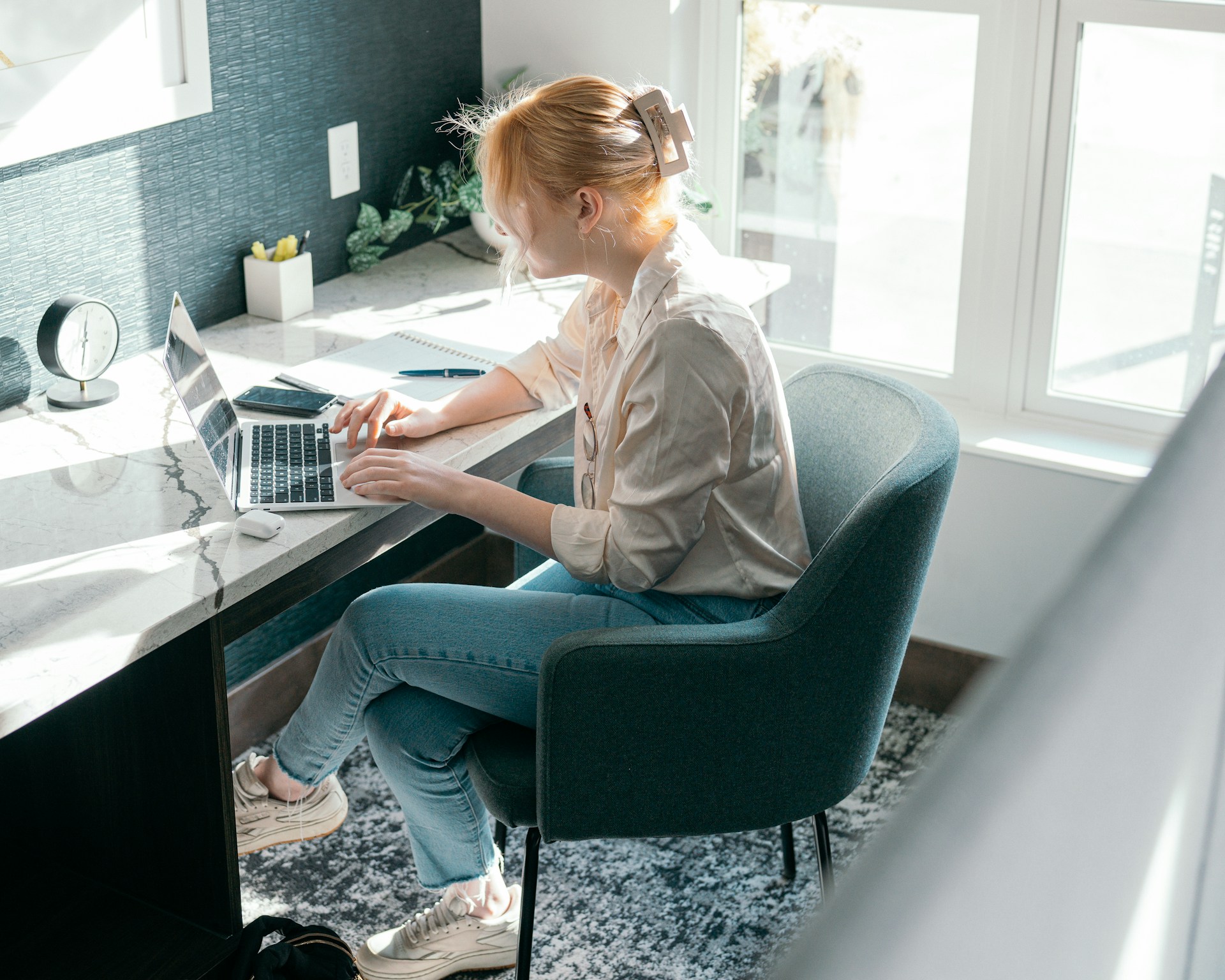 A desk with a laptop, notebook, and pen. A stack of papers labeled "Landlord Insurance" sits next to a cup of coffee