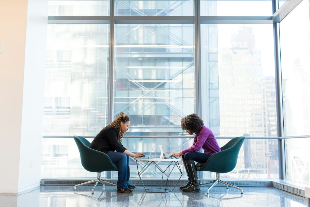 Two content creators sitting at a table coming up with essential tips for commercial real estate blog topics and ideas.