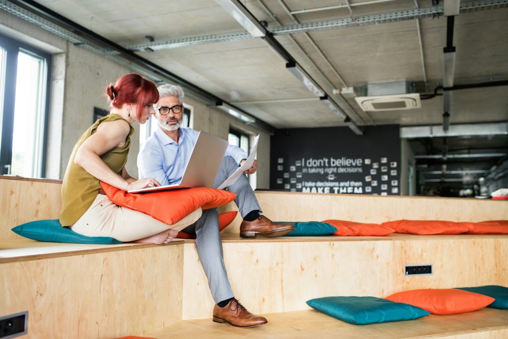 Two content creators in a shared office space strategizing about how to create and optimize website content.