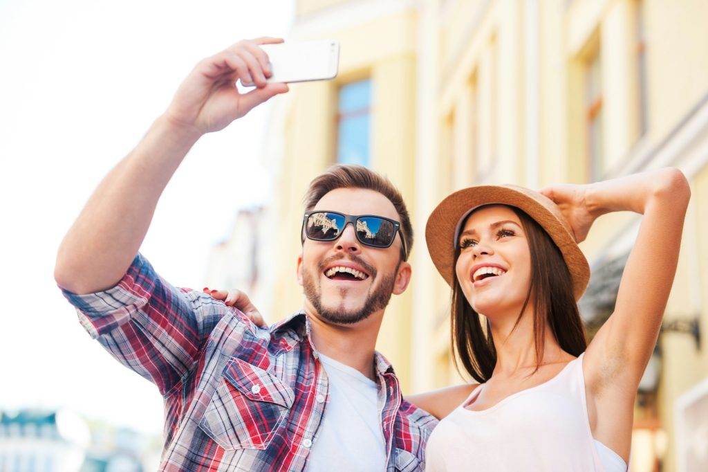 A couple using a rental property mobile app on their smartphone to find a new home.