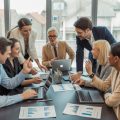 A group of people in a meeting room analyzing charts and data about real estate in an urban neighborhood.