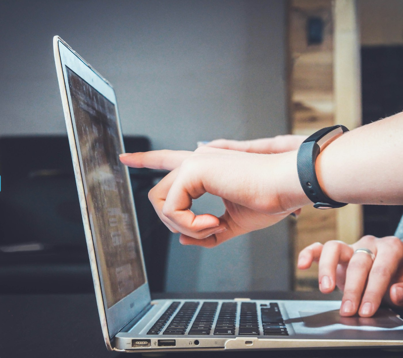 People pointing at a laptop screen