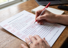 Real estate editor marking article claims, fair housing language, and marketing notes before publication